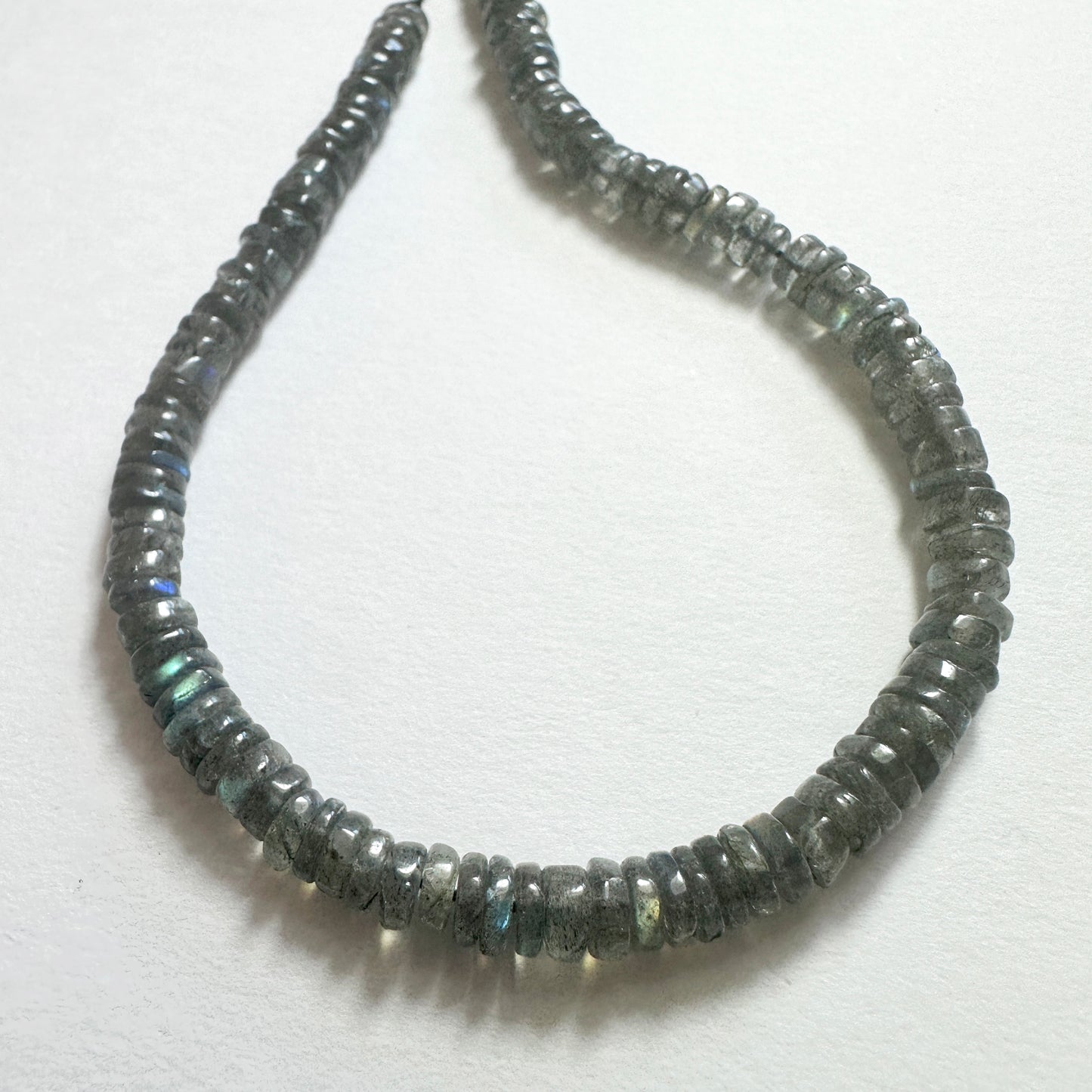 Natural gemstone beads for DIY jewellery featuring 5.1-5.4mm Labradorite wheels with polished finish and iridescent tones.