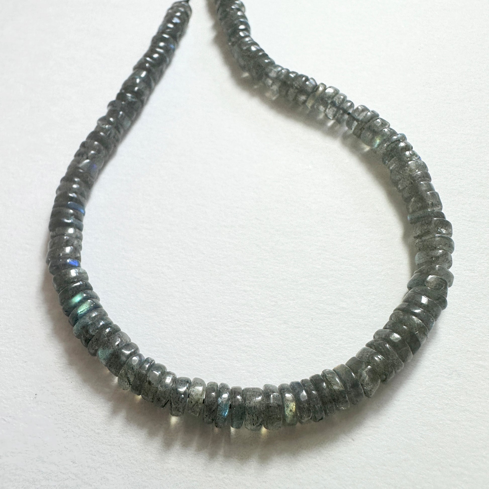 Natural gemstone beads for DIY jewellery featuring 5.1-5.4mm Labradorite wheels with polished finish and iridescent tones.