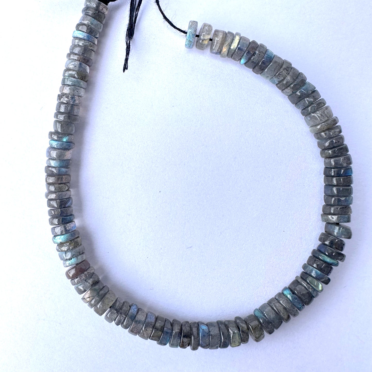 Labradorite smooth wheel beads in 6-6.2mm size with grey base and blue flashes on a 20cm strand.