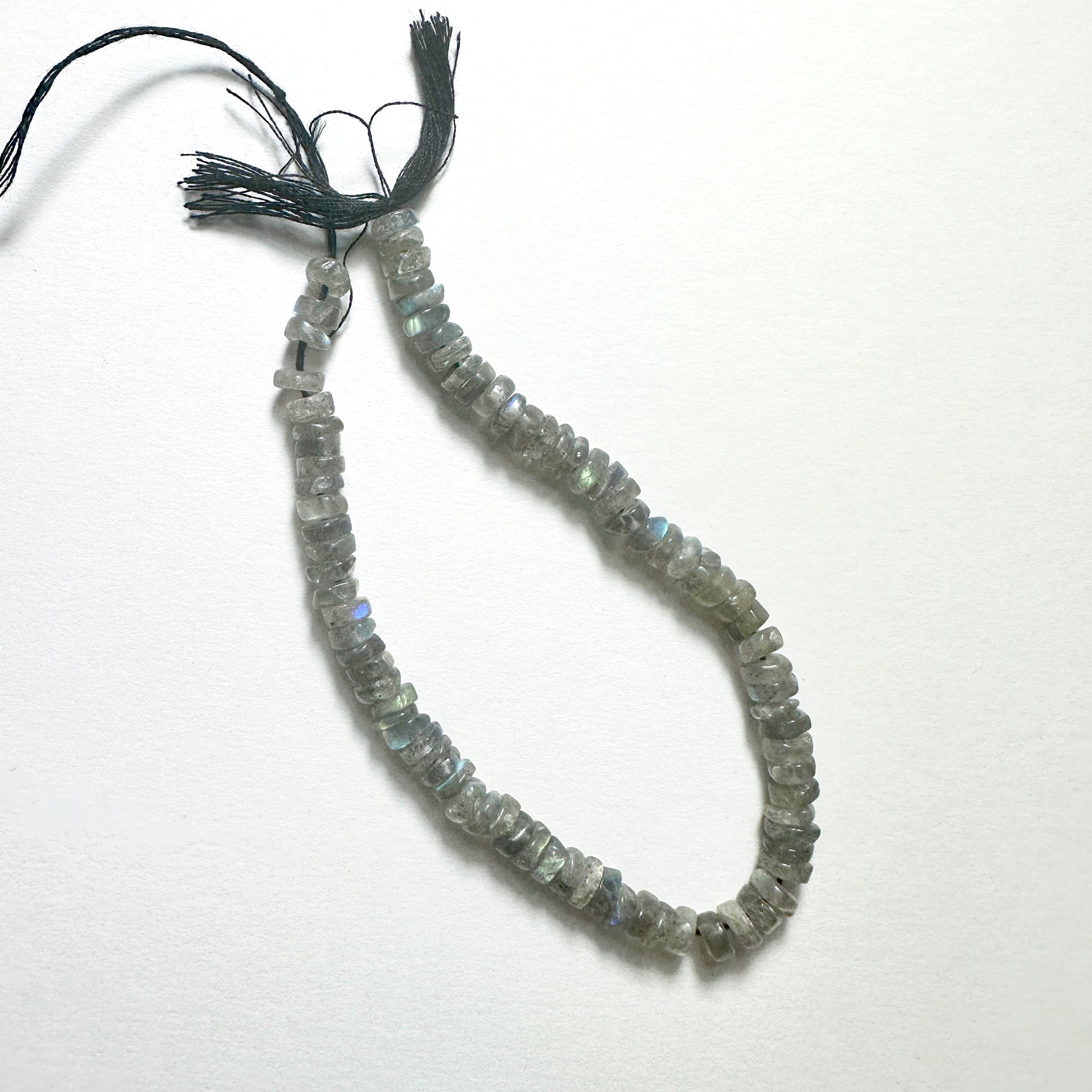 Close-up of Labradorite stone beads with smooth wheel cut, showcasing blue and green flashes for handmade jewellery components.