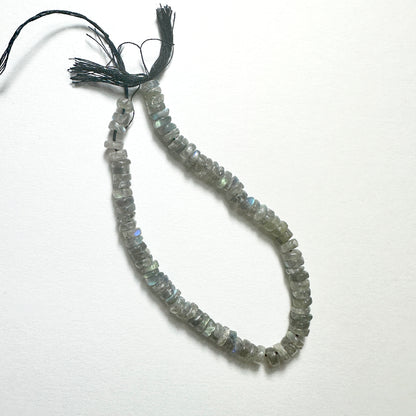 Close-up of Labradorite stone beads with smooth wheel cut, showcasing blue and green flashes for handmade jewellery components.
