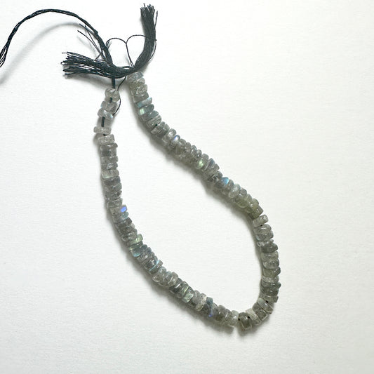 Close-up of Labradorite stone beads with smooth wheel cut, showcasing blue and green flashes for handmade jewellery components.