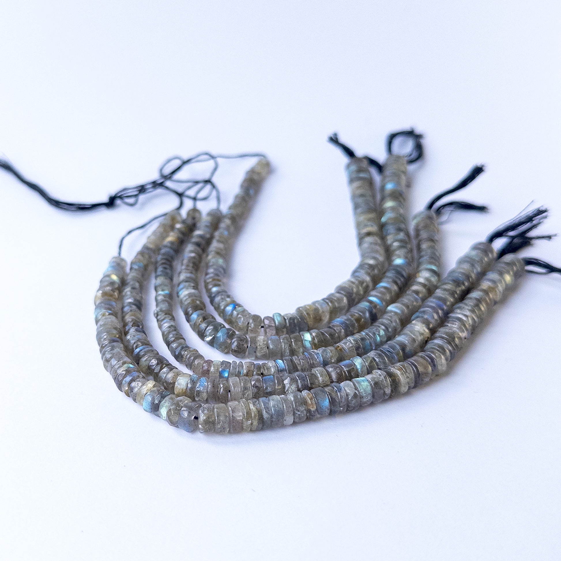Labradorite smooth wheel gemstone beads showing natural labradorescence on a 20cm strand for handmade jewellery components.