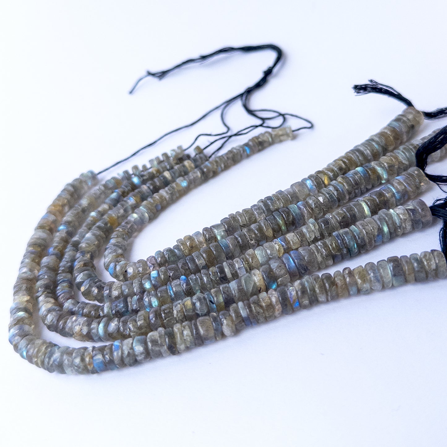 Authentic Labradorite smooth wheel beads arranged on a strand, showcasing natural shimmer and quality polish.