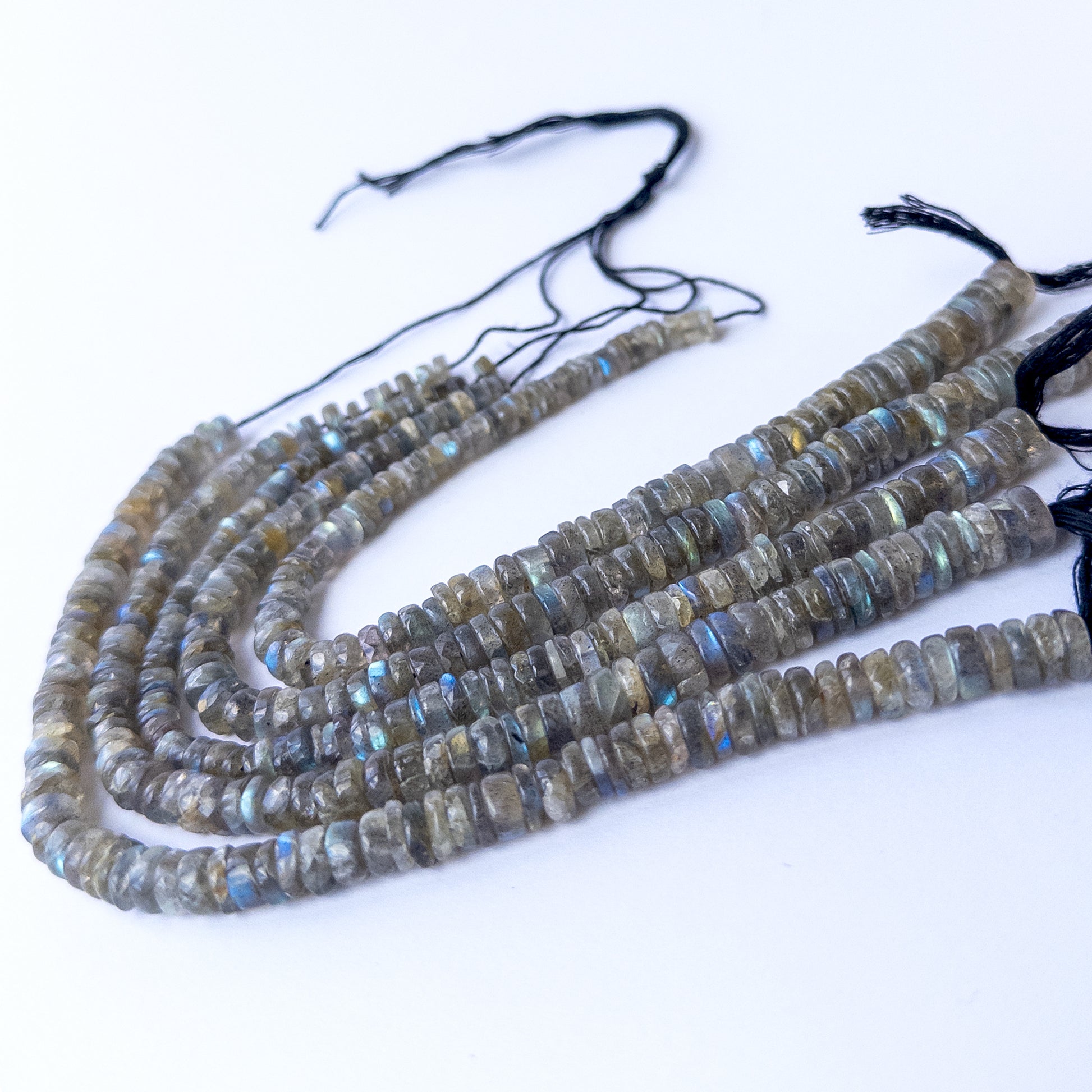 Authentic Labradorite smooth wheel beads arranged on a strand, showcasing natural shimmer and quality polish.