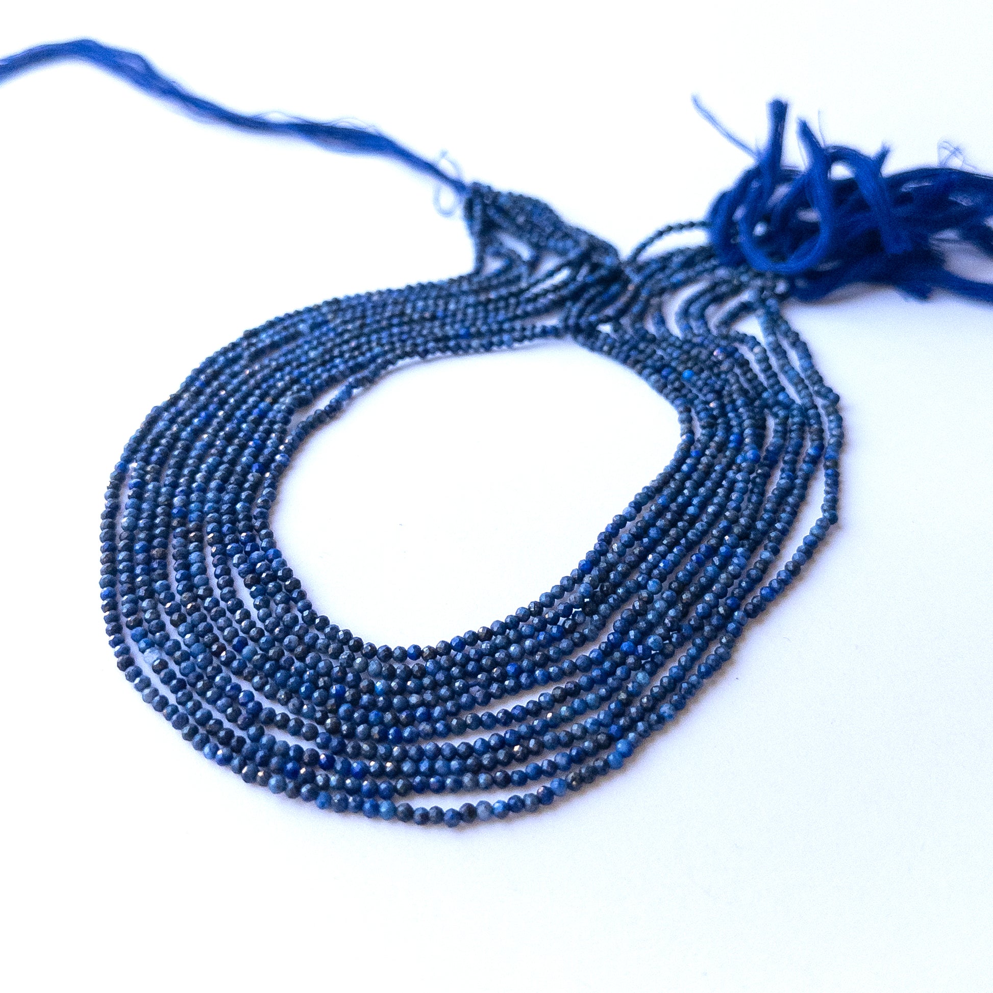 Close‑up of genuine lapis lazuli faceted rondelle gemstone beads with natural gold flecks for DIY jewellery making.
