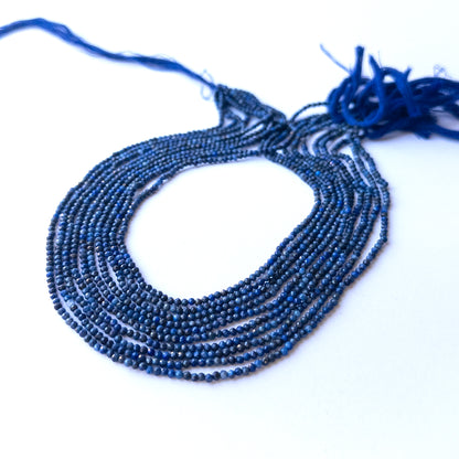 Close‑up of genuine lapis lazuli faceted rondelle gemstone beads with natural gold flecks for DIY jewellery making.