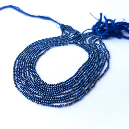 Close‑up of genuine lapis lazuli faceted rondelle gemstone beads with natural gold flecks for DIY jewellery making.