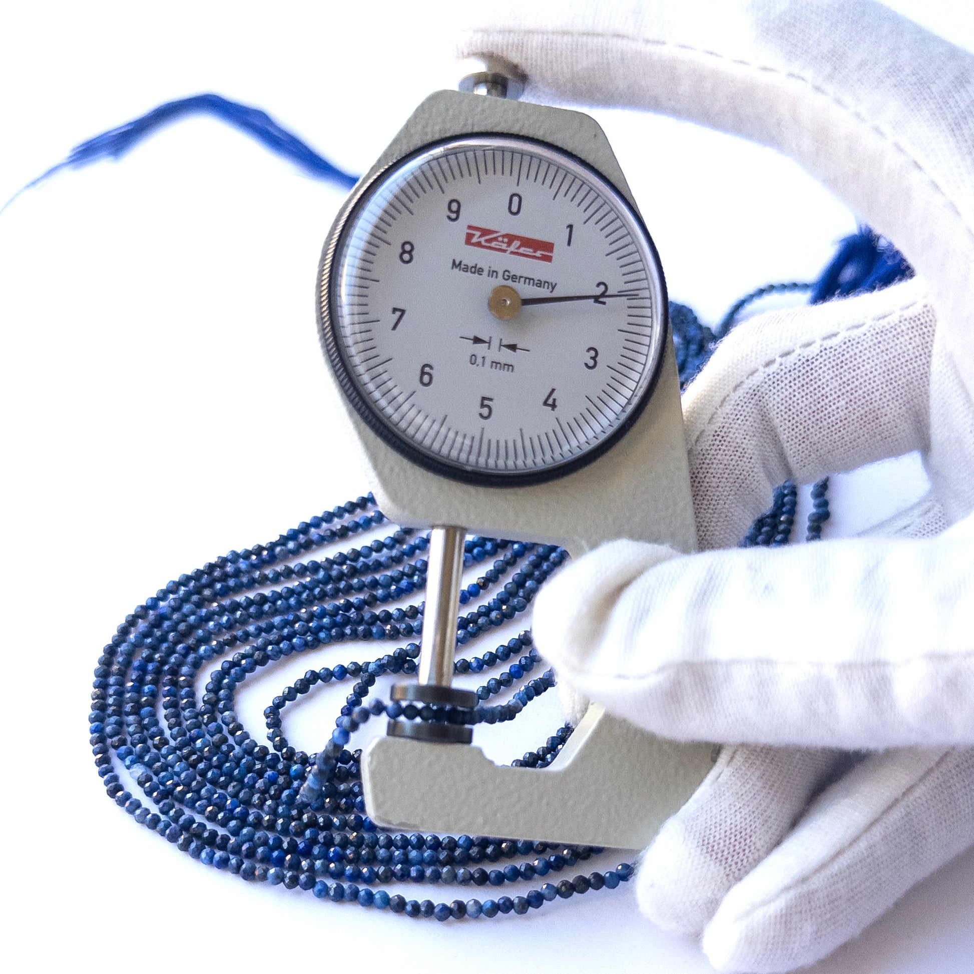 A dial gauge measures the Lapis Lazuli Faceted Rondelle 3.2mm gemstone.