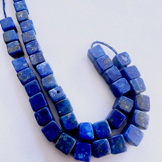 Lapis Lazuli cube-cut beads with deep blue colour and polished surface arranged neatly across a short strand.