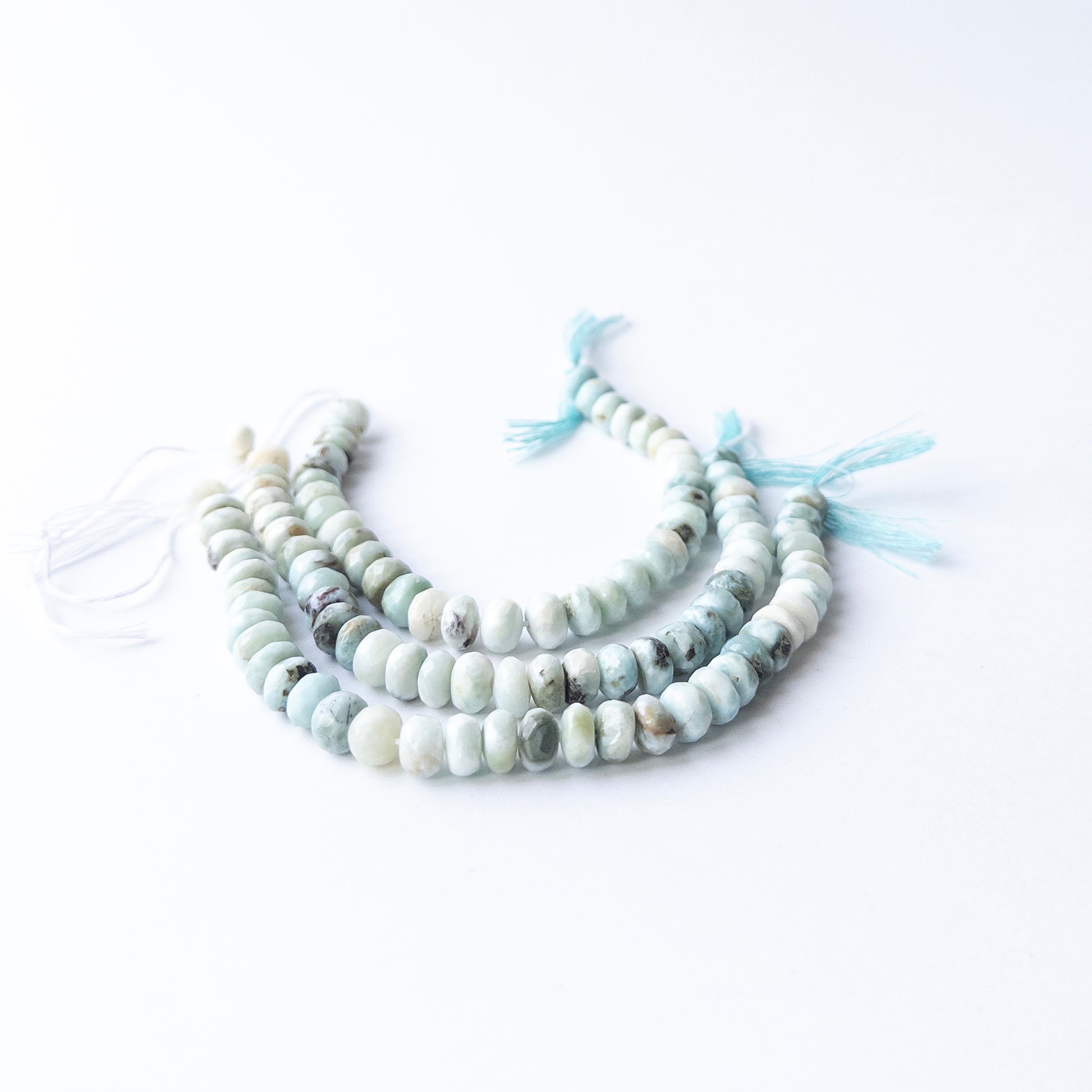 Genuine Larimar gemstone beads displaying soft blue tones, polished facets, and a neatly arranged 16cm strand for jewellery design.