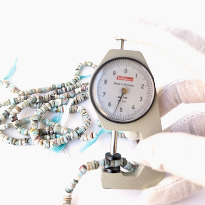 A dial gauge measures the Larimar smooth wheel 4.5–6mm gemstone.