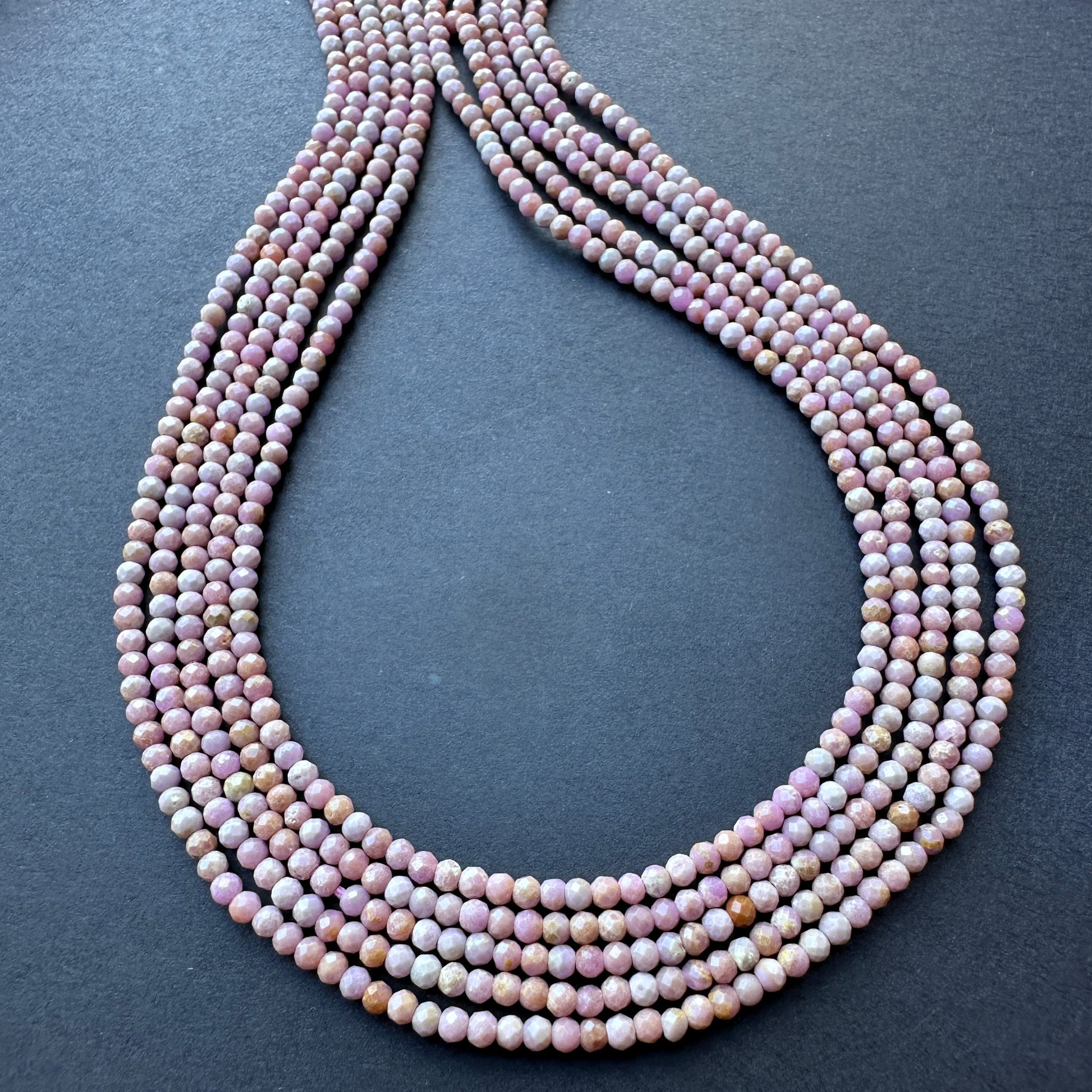 Lavender Opal faceted rondelle beads arranged in a neat strand, showcasing natural gemstone beads for DIY jewellery.