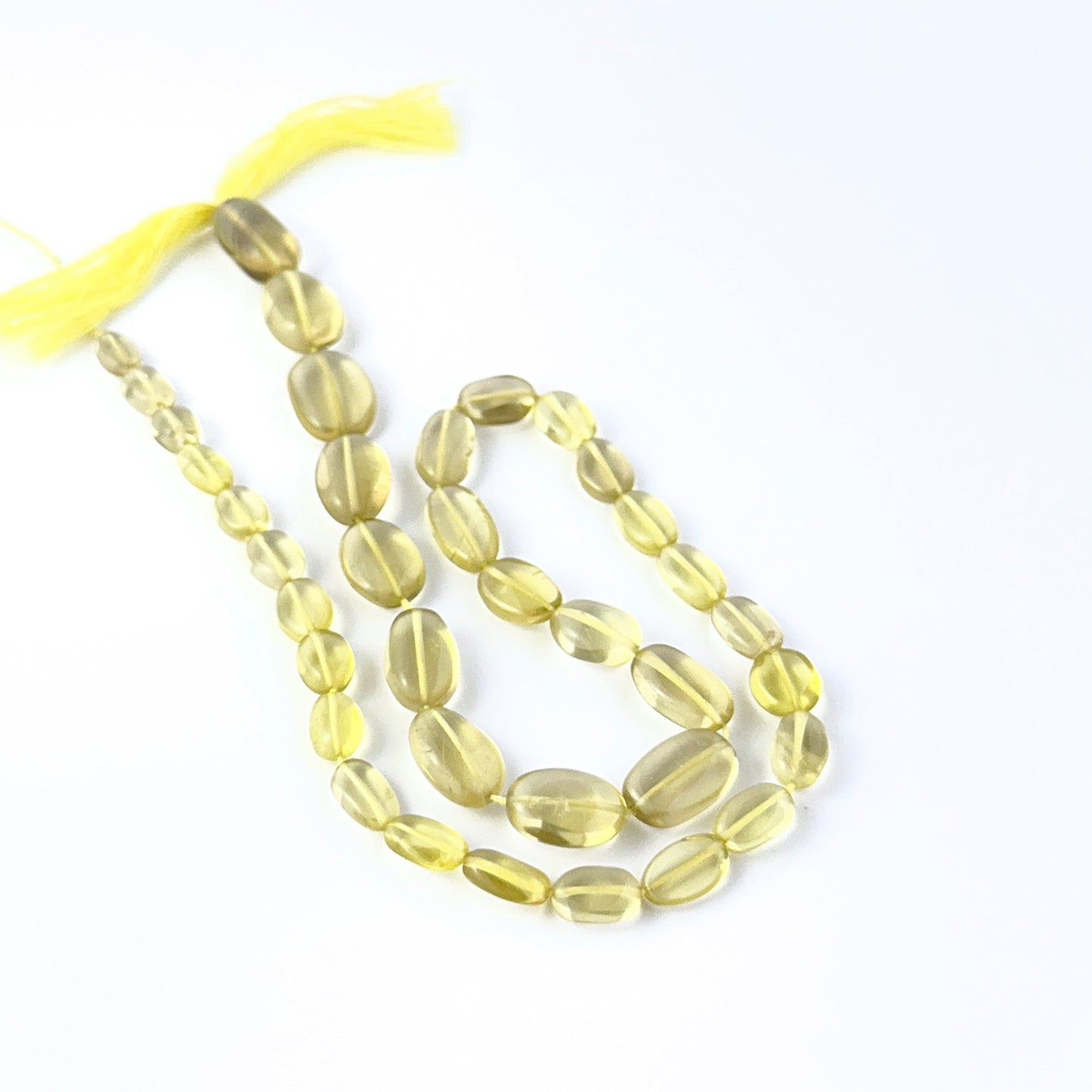 Lemon Quartz smooth oval gemstone beads showing bright yellow tones and polished clarity.