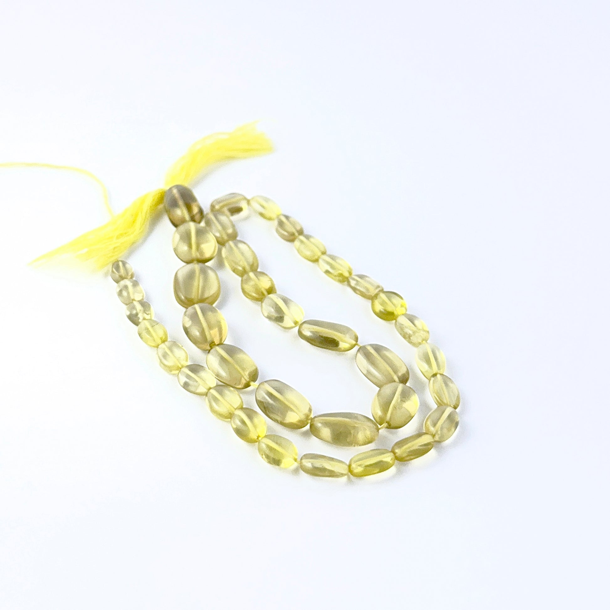 Smooth oval Lemon Quartz beads arranged neatly, highlighting their glossy finish and handmade jewellery component quality