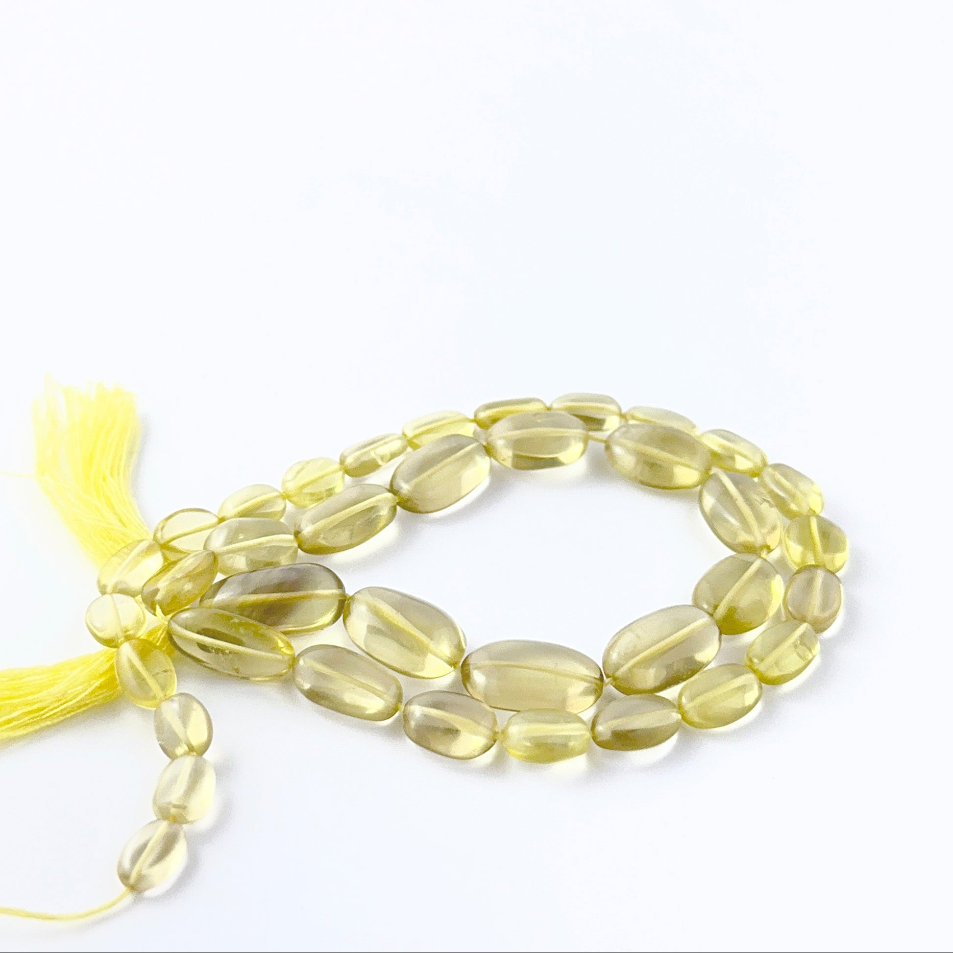Lemon Quartz smooth oval beads in a long strand, displaying mixed sizes and refined craftsmanship