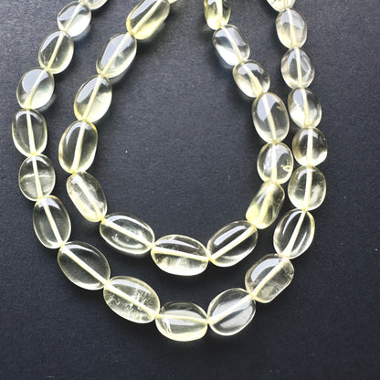 Close-up of Lemon Quartz beads showcasing their bright colour and sleek oval shape.