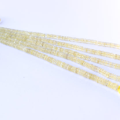 A person holds delicate strands of Lemon Quartz beads, showcasing their smooth wheel design.