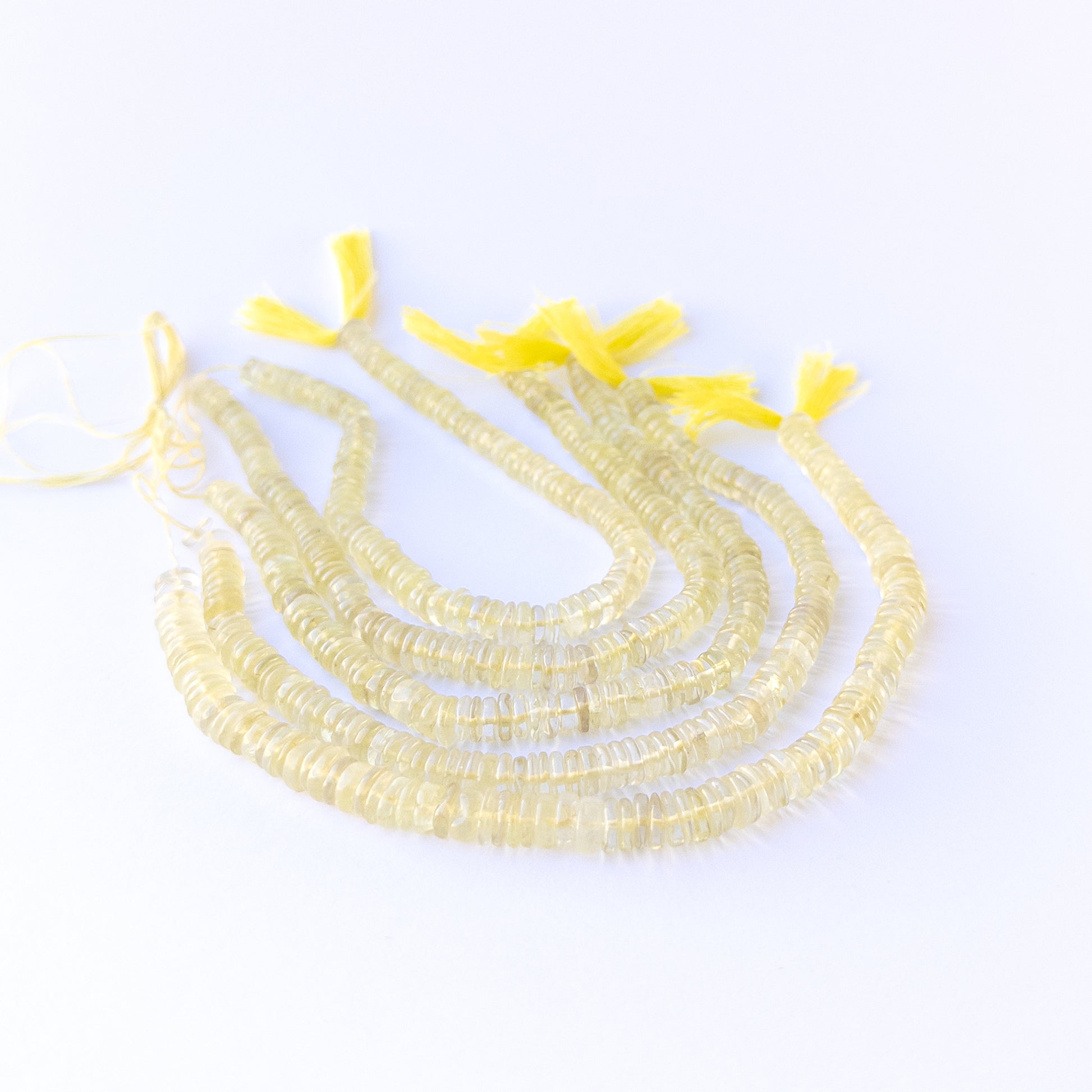 Handmade jewellery components featuring natural lemon quartz smooth wheels with vibrant yellow tones.