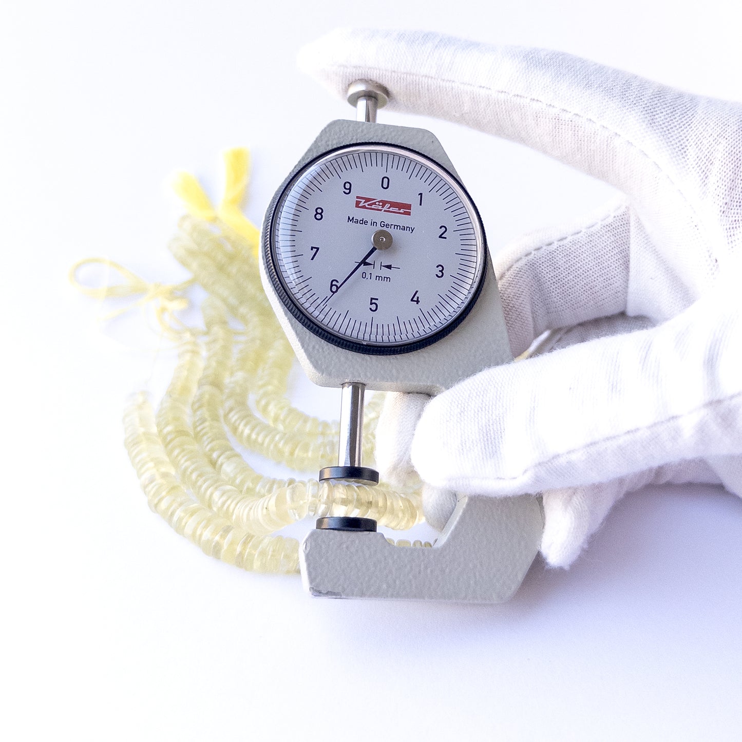 A dial gauge measures the Lemon Quartz smooth wheel 6–6.5mm gemstone.
