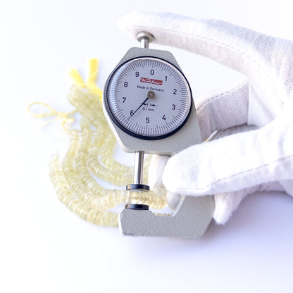 A dial gauge measures the Lemon Quartz smooth wheel 6–6.5mm gemstone.