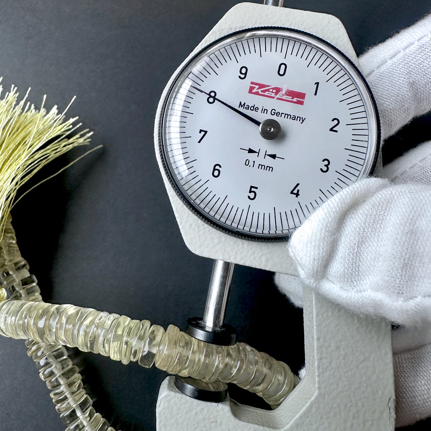 A dial gauge measures the Lemon Quartz smooth wheel 7.5-8mm gemstone.