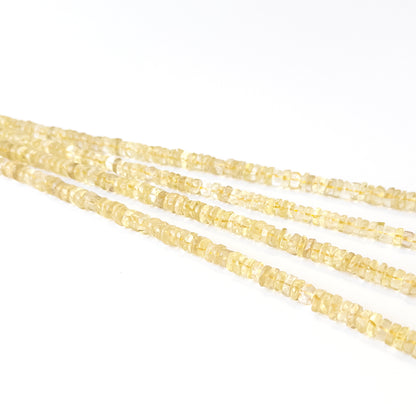 Genuine Lemon Quartz gemstone beads showcasing smooth wheel cuts arranged neatly on a 33cm strand.