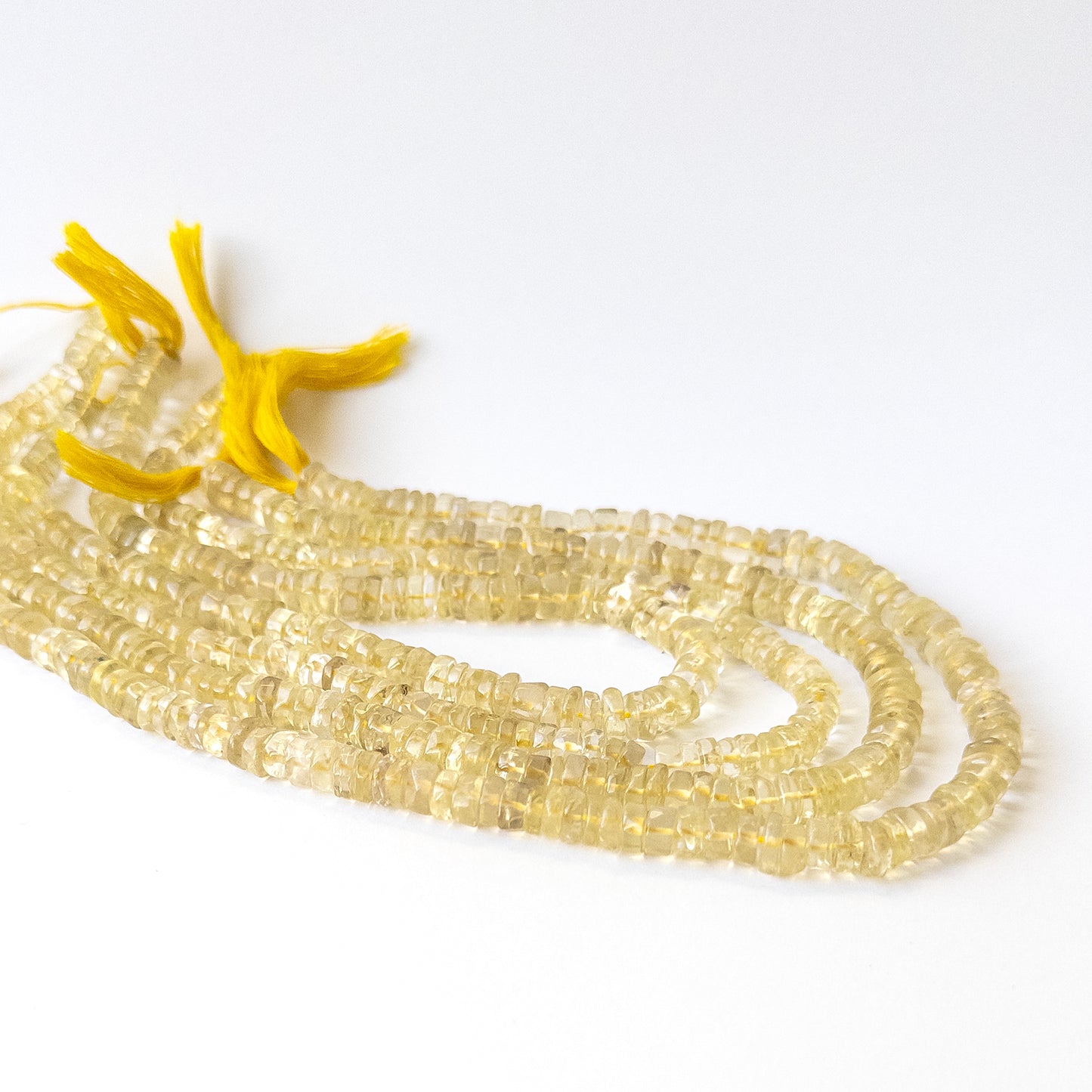 Natural Lemon Quartz stone beads with soft yellow tones and smooth wheel shapes, perfect for artisan jewellery.