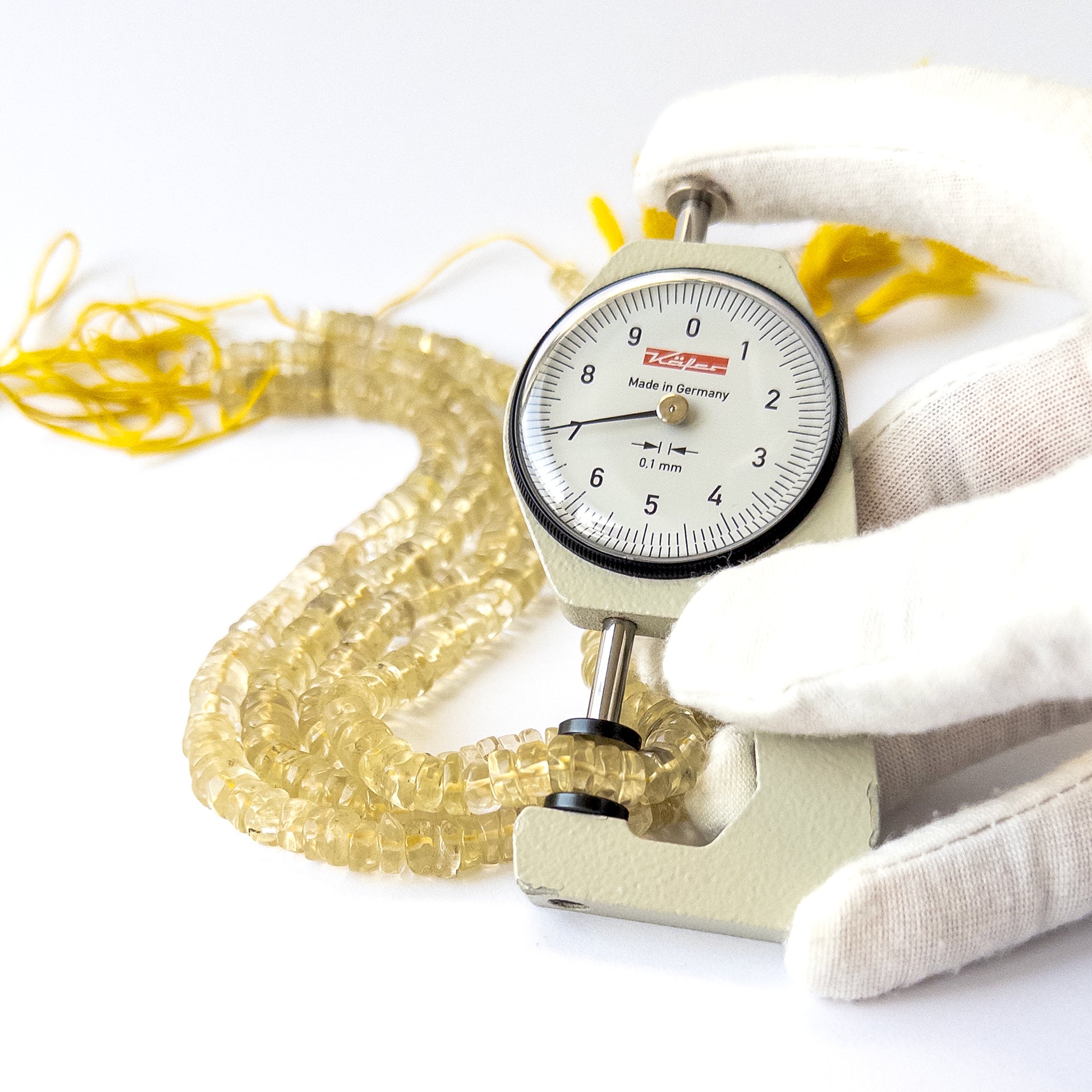 A dial gauge measures the Lemon Quartz smooth wheel 6–7.5mm gemstone.