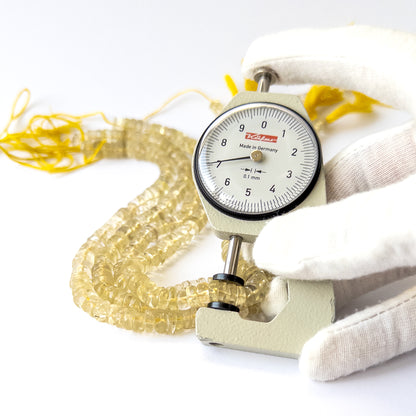 A dial gauge measures the Lemon Quartz smooth wheel 6–7.5mm gemstone.
