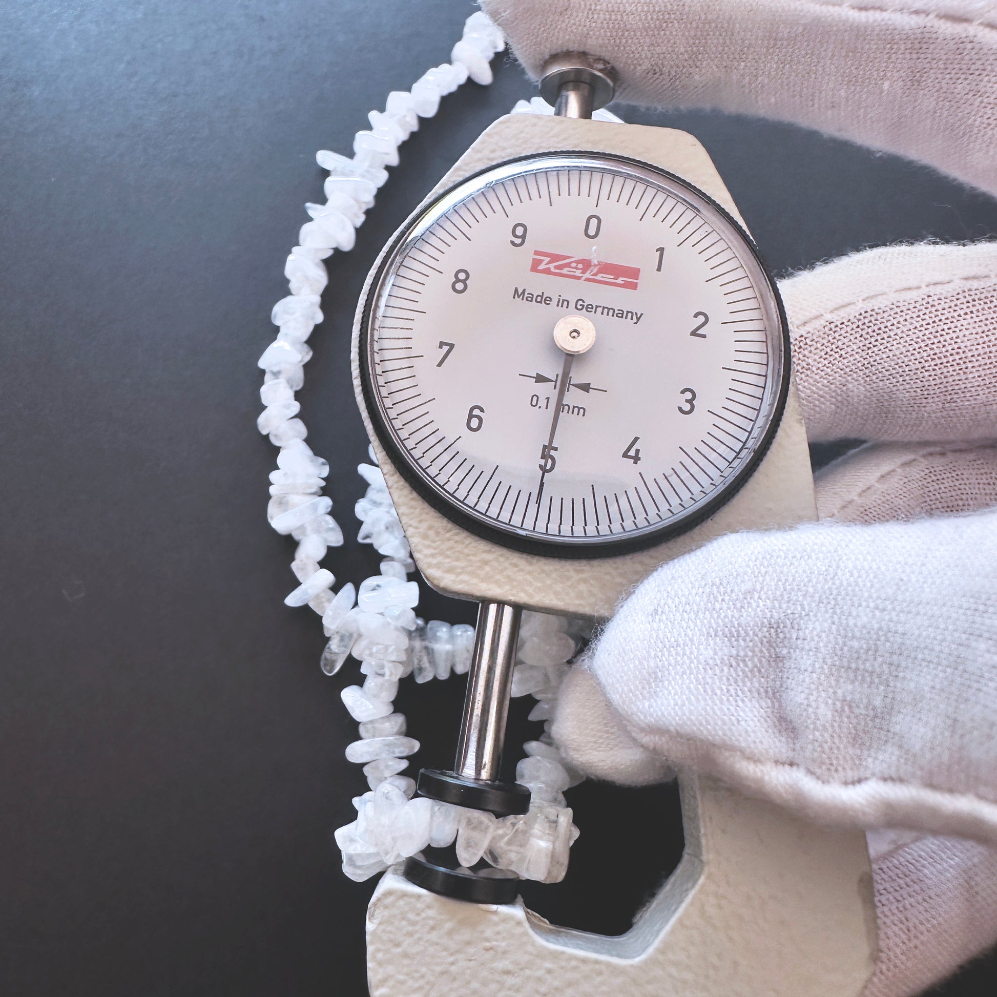 A dial gauge measures the Moonstone chips 4-5mm gemstone.