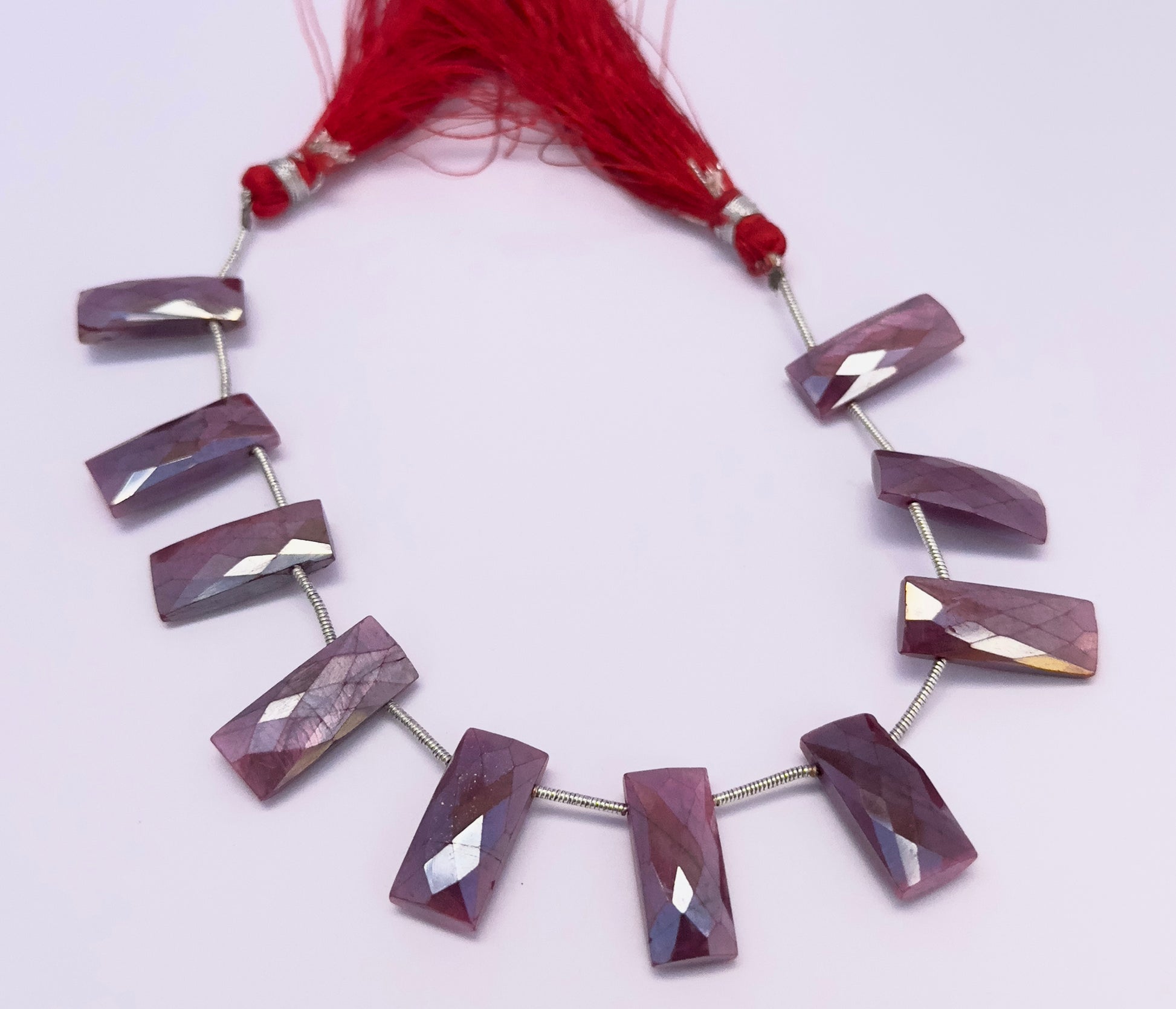 Natural Moonstone Coated stone beads arranged in a strand with shimmering highlights.