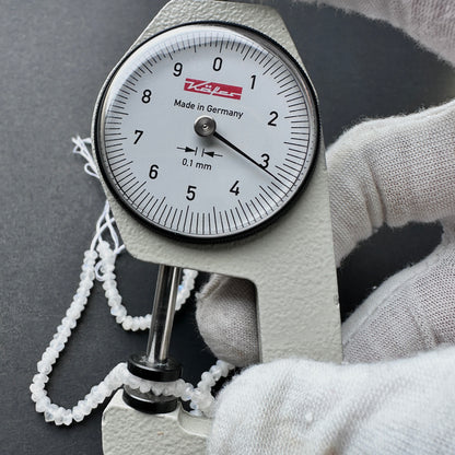 A dial gauge measures the Moonstone faceted rondelle 3.2mm gemstone.