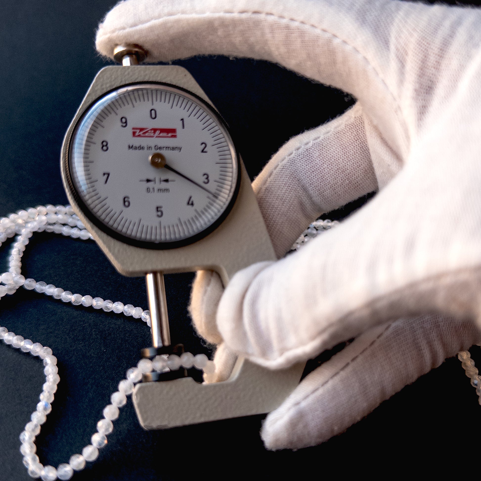 A dial gauge measures the Moonstone faceted rondelle 3.4mm gemstone.