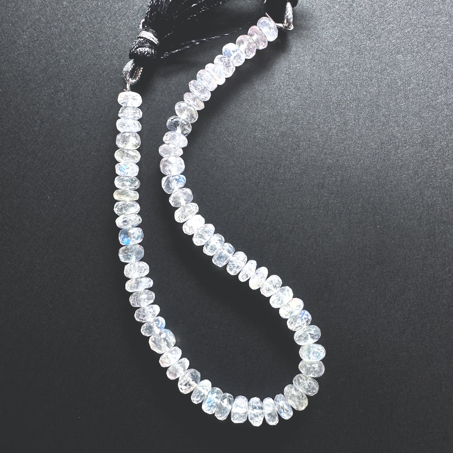 Close-up of Moonstone beads showcasing their shimmering hues and detailed cut.