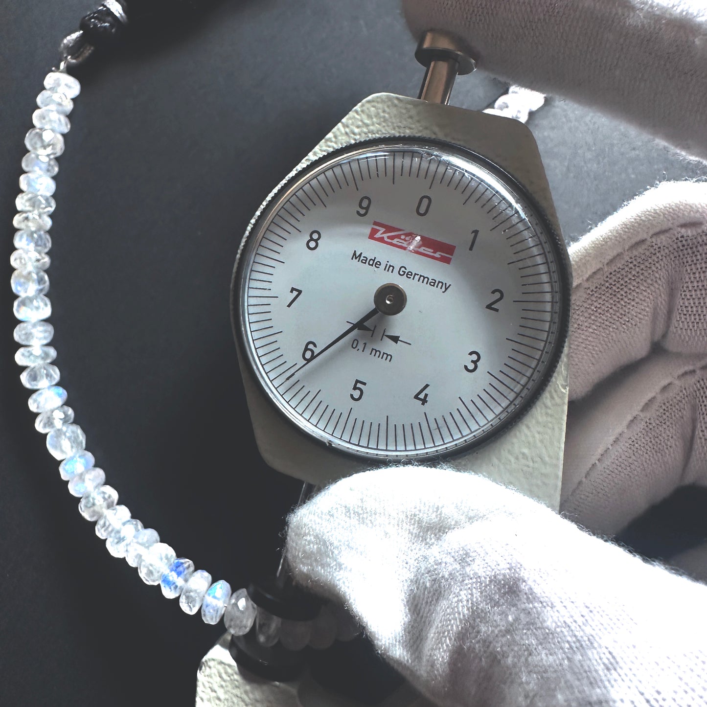A dial gauge measures the Moonstone faceted rondelle gemstone.
