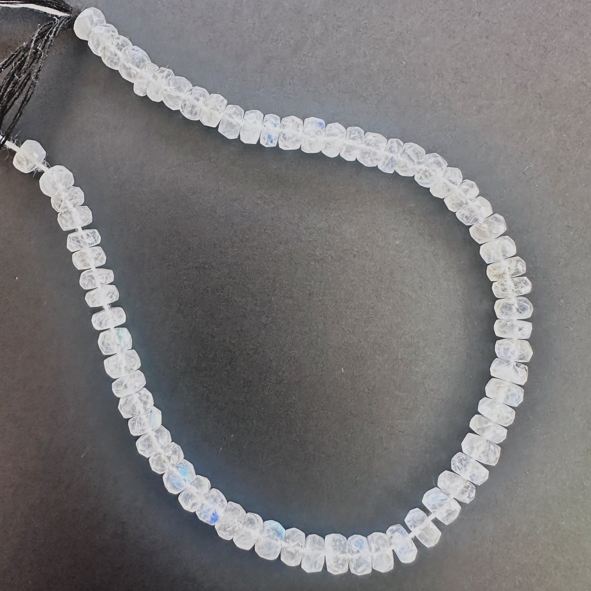 Close-up of Moonstone faceted rondelle beads with luminous white tones and blue sheen.