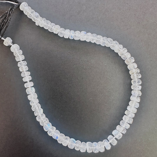 Close-up of Moonstone faceted rondelle beads with luminous white tones and blue sheen.