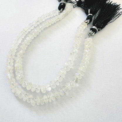 Smooth Moonstone rondelles with soft greys and creams displayed across beading thread.