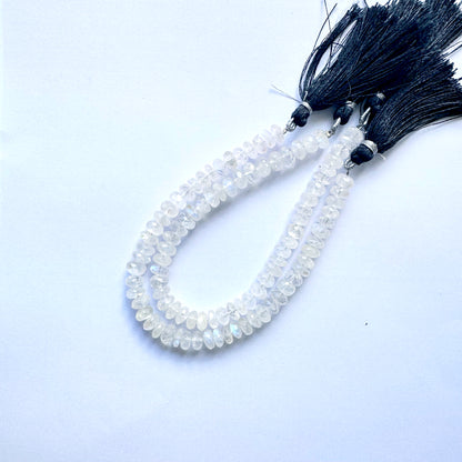 Gleaming moonstone rondelle gemstones arranged in a uniform pattern on thread.