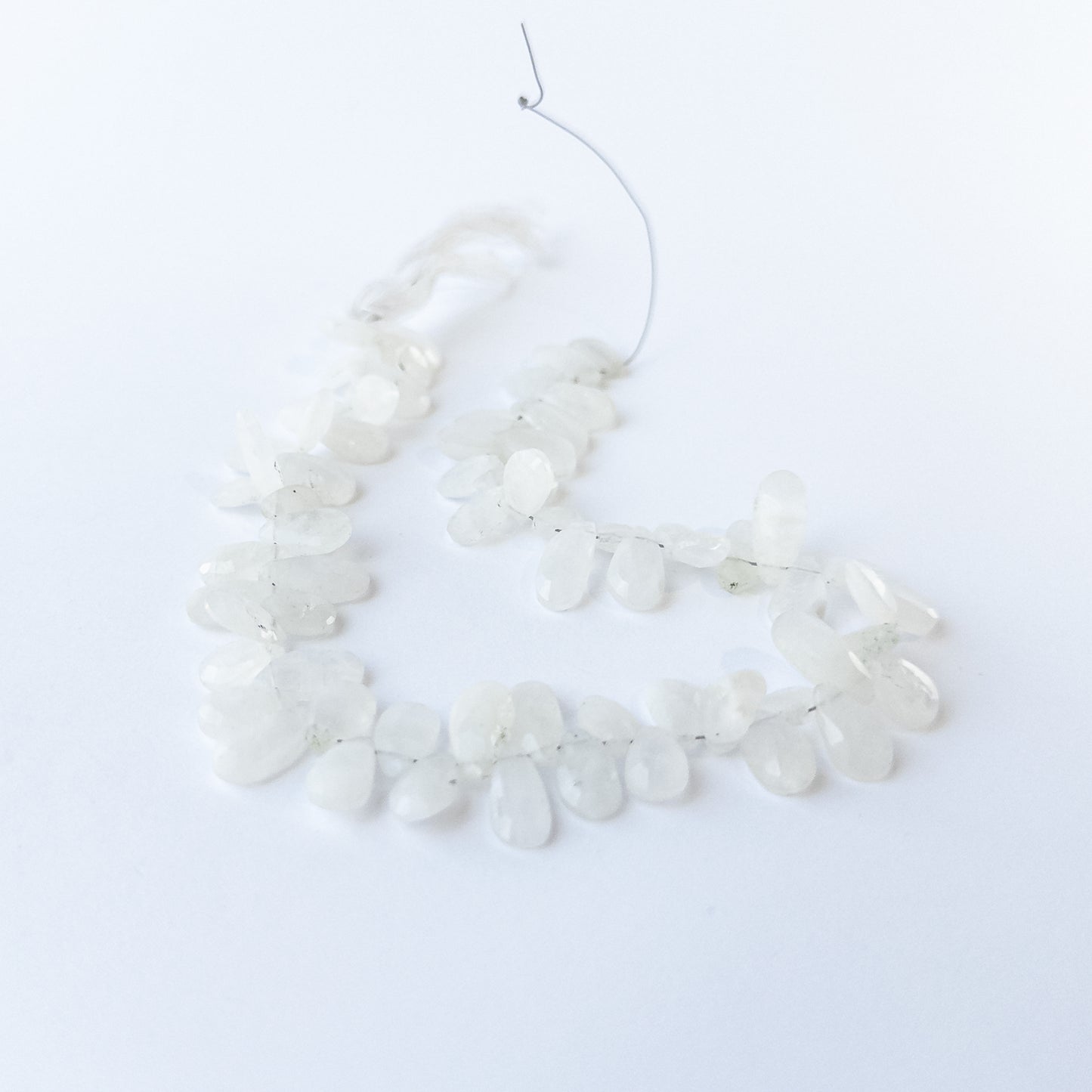 Handmade jewellery components featuring Rainbow Moonstone briolettes with polished facets and luminous sheen.