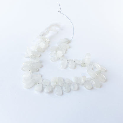 Handmade jewellery components featuring Rainbow Moonstone briolettes with polished facets and luminous sheen.