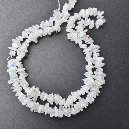 Close-up of Moonstone smooth chip beads with soft white tones and subtle blue flashes.