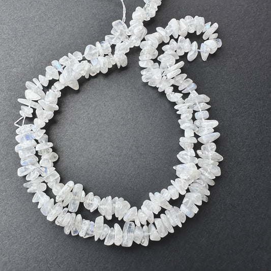 Close-up of Moonstone smooth chip beads with soft white tones and subtle blue flashes.