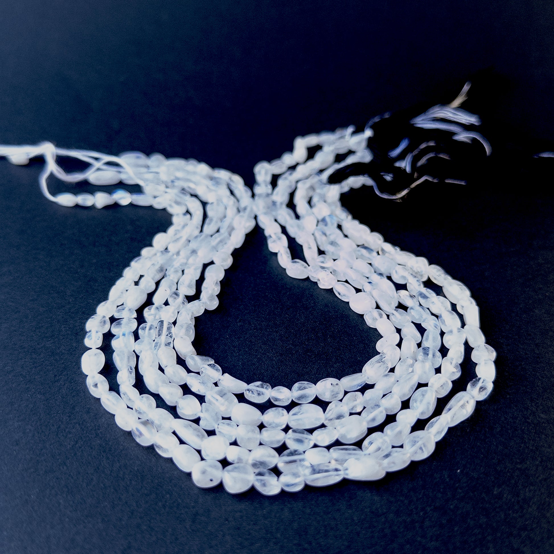 Moonstone smooth tumble beads in 4.5–5.3mm size on a 32cm strand, showcasing natural shimmer and glow.