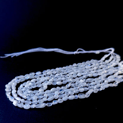 Genuine stone beads with soft white tones and rainbow flashes, featuring smooth tumbles for DIY jewellery making.