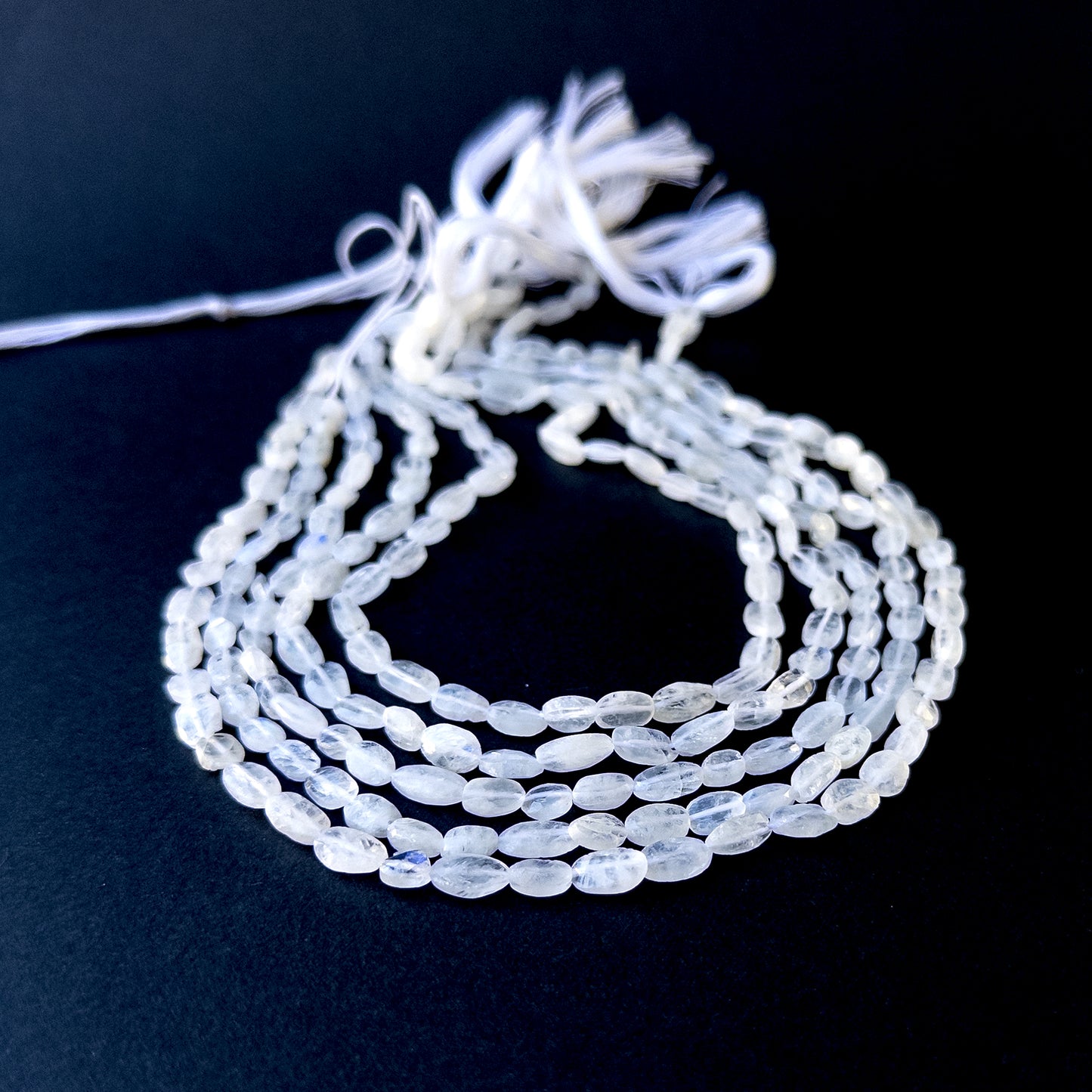 Genuine stone beads with soft white tones and rainbow flashes, featuring smooth tumbles for DIY jewellery making.