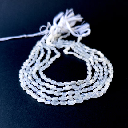 Genuine stone beads with soft white tones and rainbow flashes, featuring smooth tumbles for DIY jewellery making.