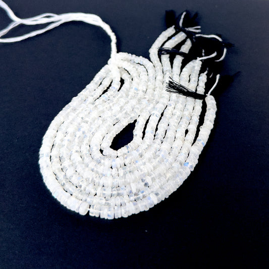 Moonstone smooth wheel beads in soft white tones arranged on a strand for handmade jewellery components.