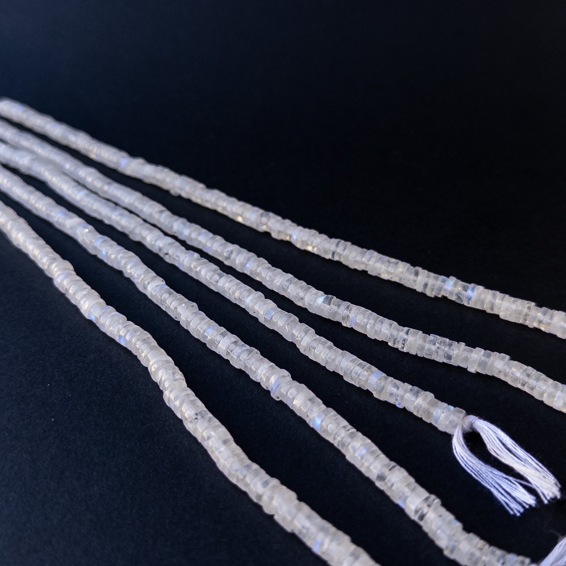 Premium moonstone gemstone beads for DIY jewellery, displaying smooth wheel cuts and subtle rainbow sheen.